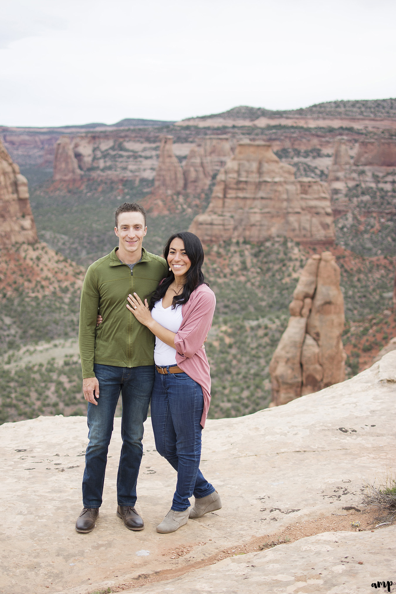 Engaged couple standing before a canyon in the Colorado National Monument