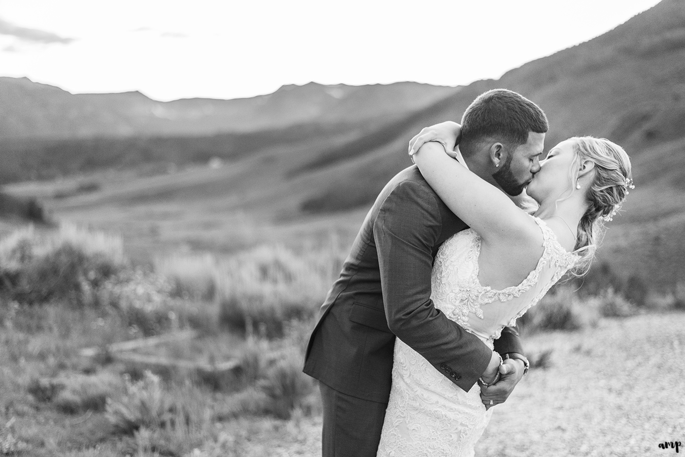 Bride and groom kissing with Crested Butte in background