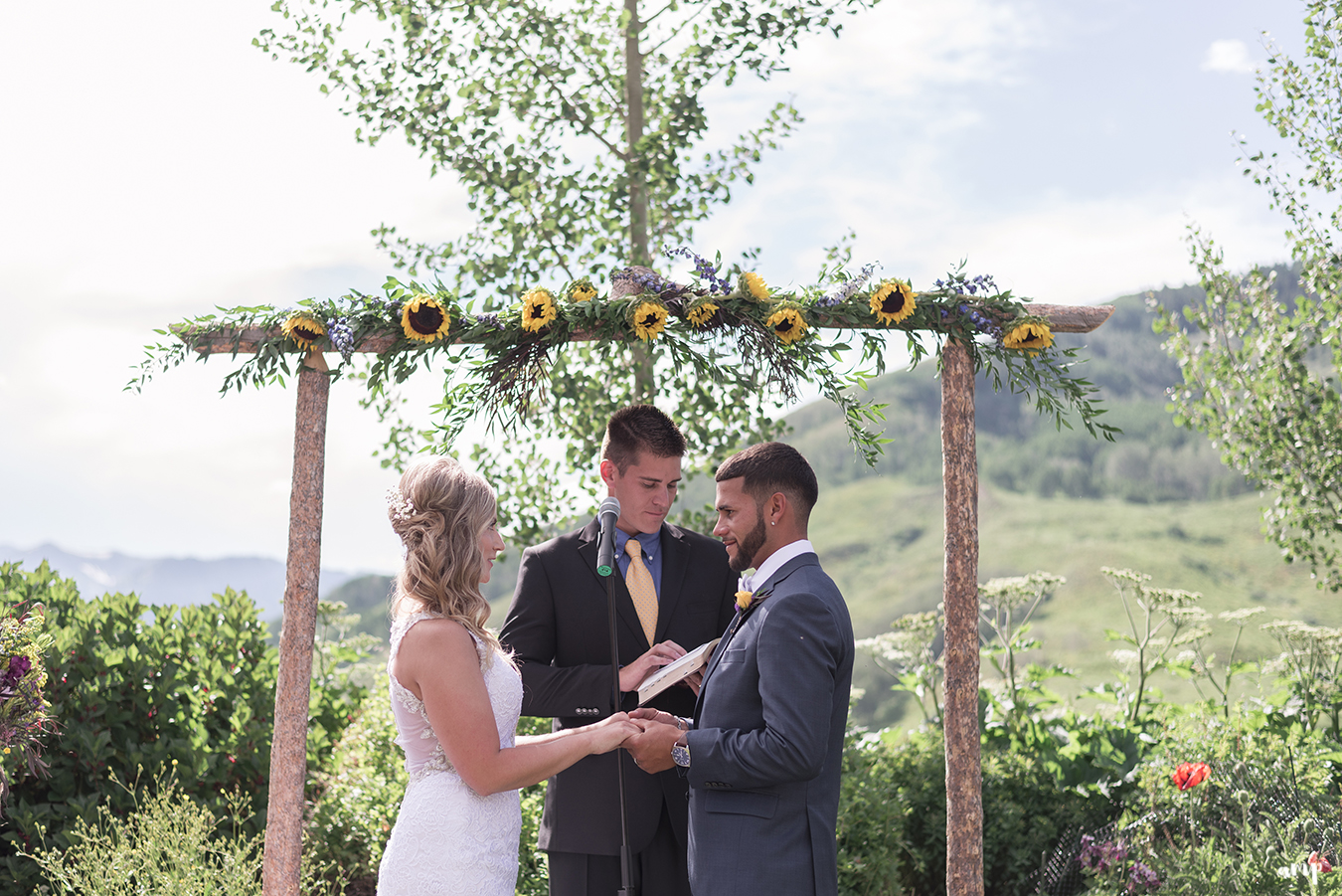 Bride and groom at the wooden arch altar of the Crested Butte Mountain Wedding Garden
