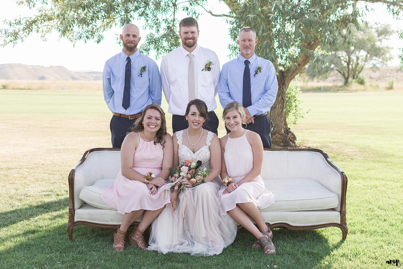 Bridal party sits on vintage sofa couch