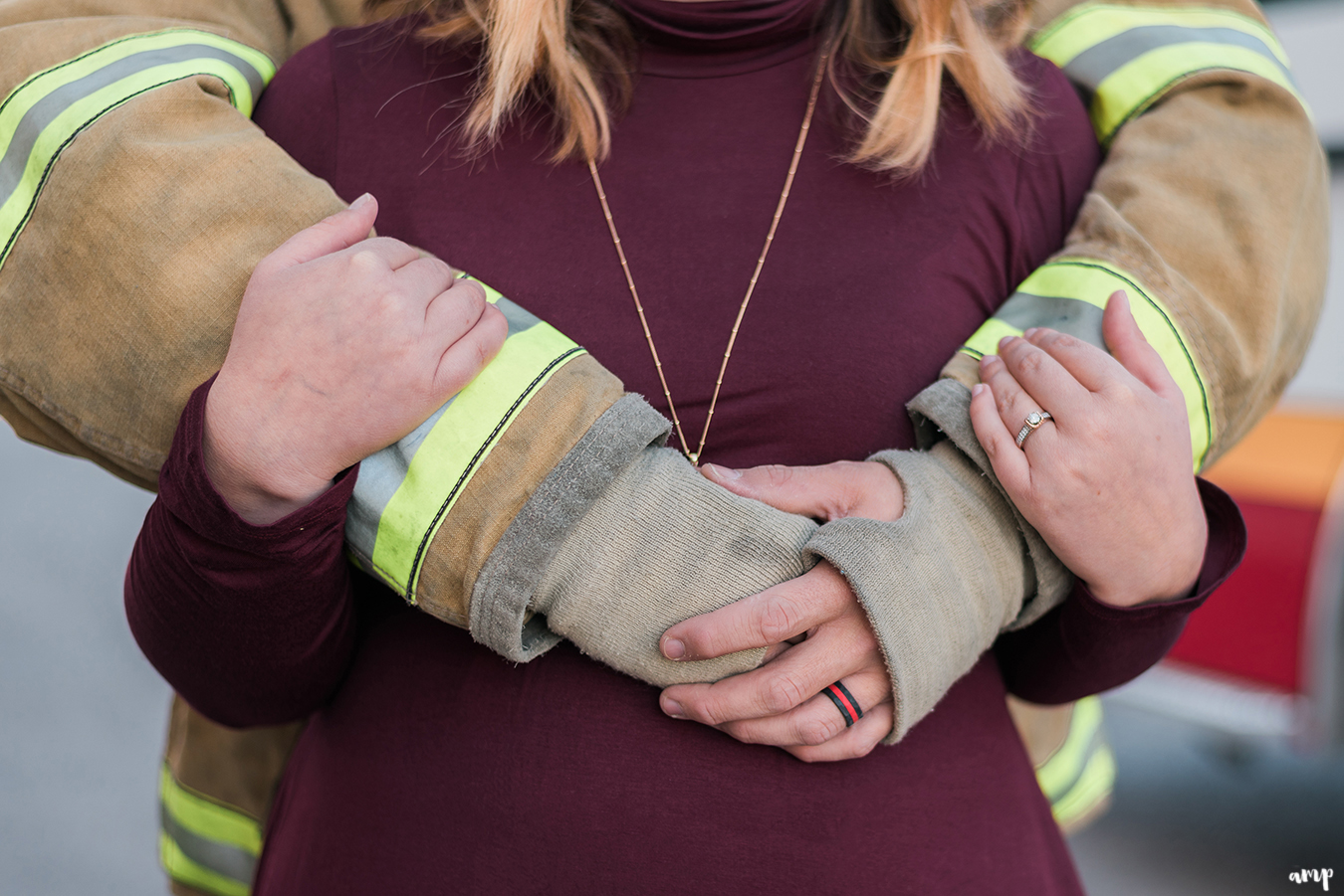 Firefighter and firefighter's wife cuddling, showing off the rings
